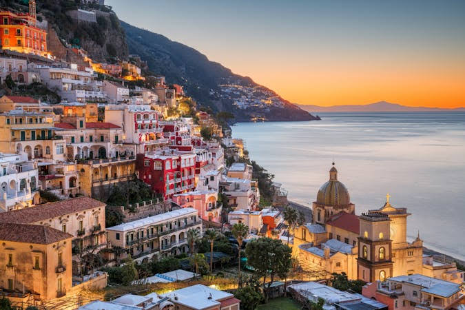 Vista panorâmica da Costa Amalfitana em Positano ao pôr do sol com casas coloridas nas falésias