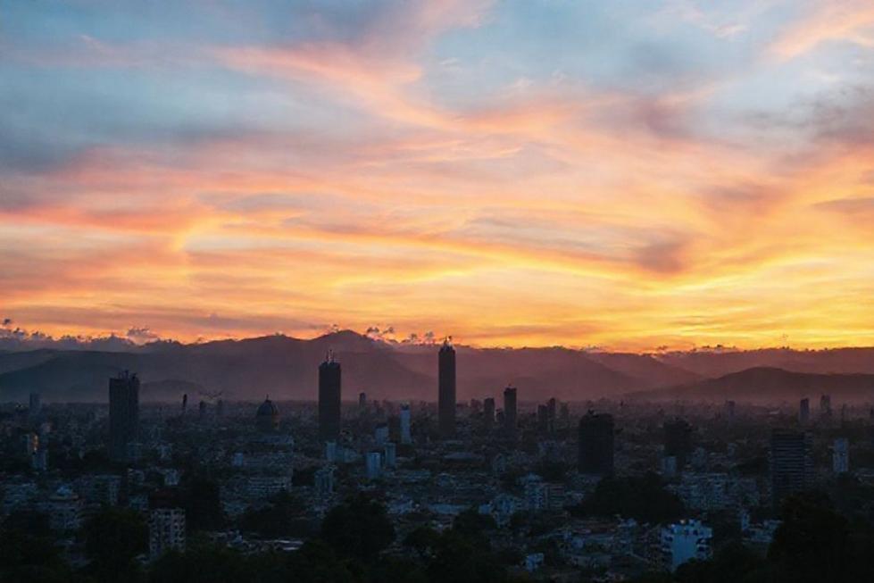 Vista da cidade de Belo Horizonte ao pôr do sol iluminando seus marcos icônicos.