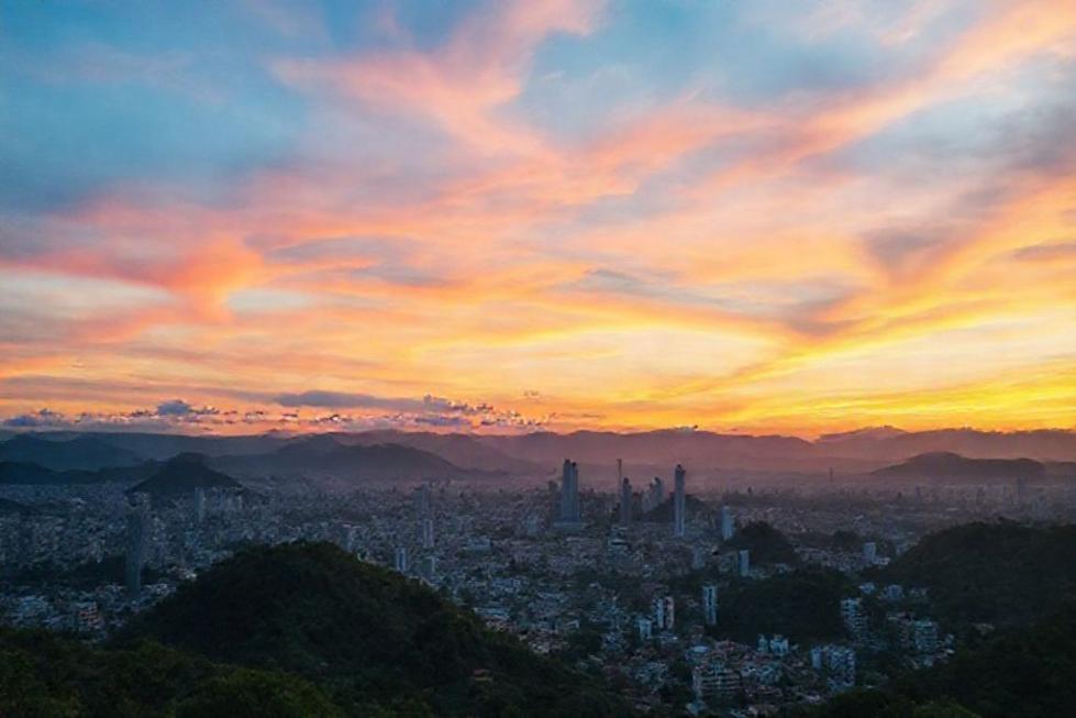 Pôr do sol sobre o horizonte de Belo Horizonte, com colinas e cores vibrantes.