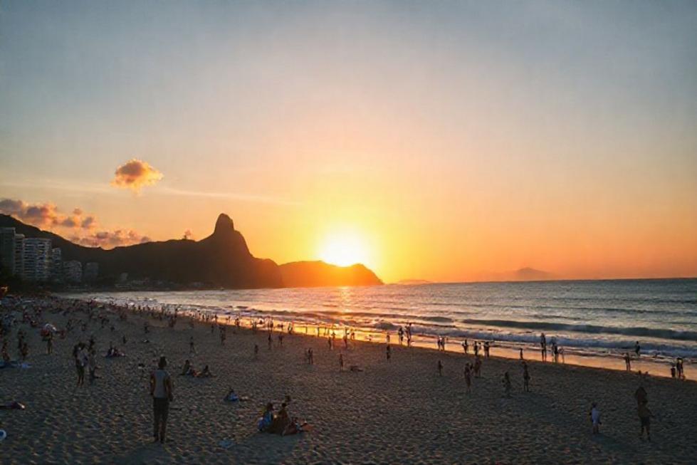 Turistas na praia de Copacabana durante o pôr do sol.