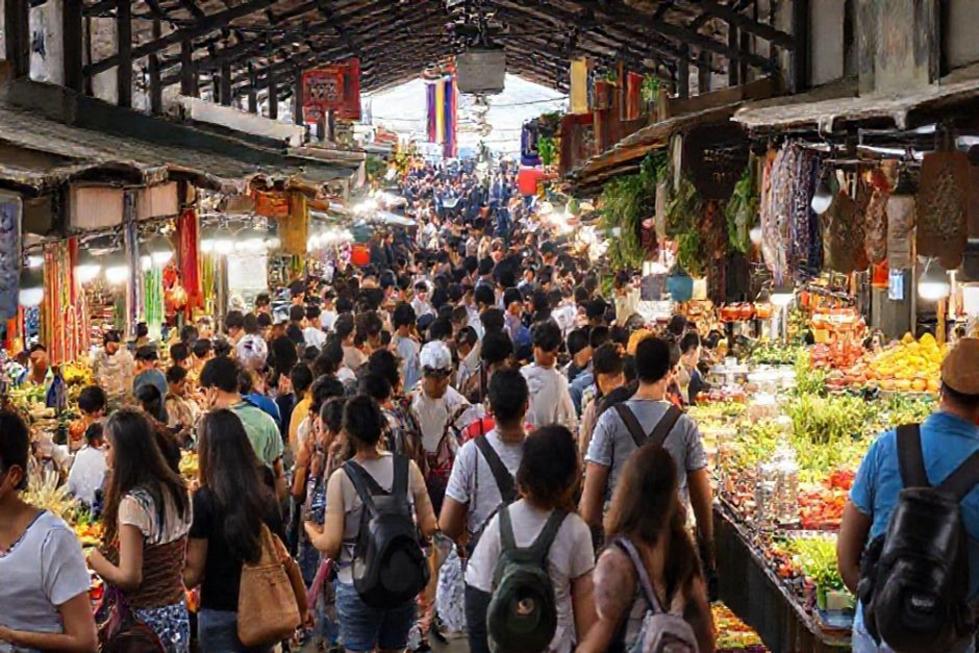 Mercado movimentado em Bogotá com pessoas desfrutando da cultura local.