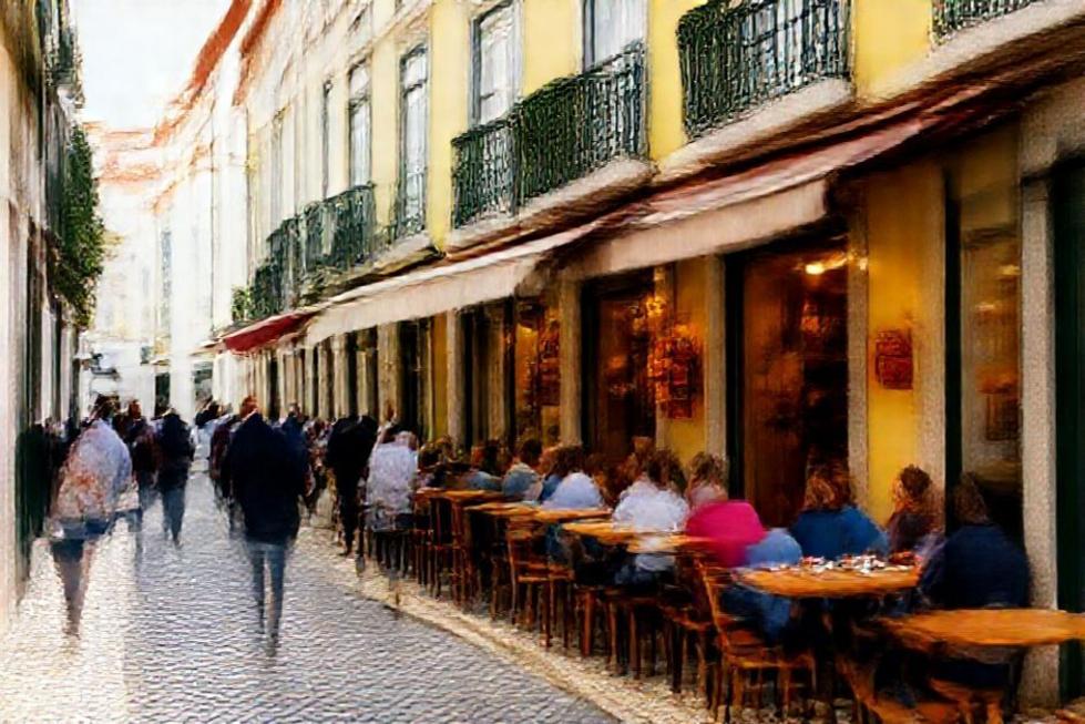 Rua movimentada em Lisboa com lojas e restaurantes.