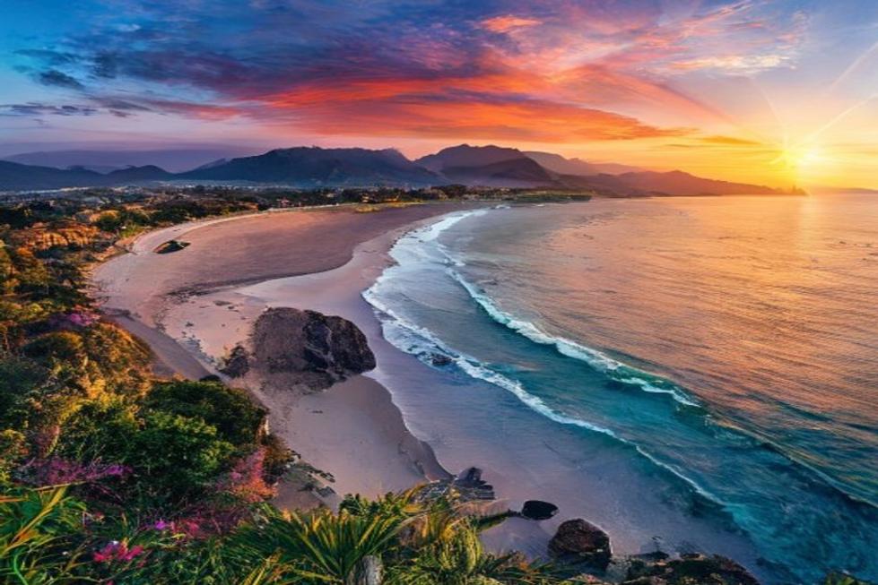 Vista panorâmica de Florianópolis com praias e montanhas ao fundo.