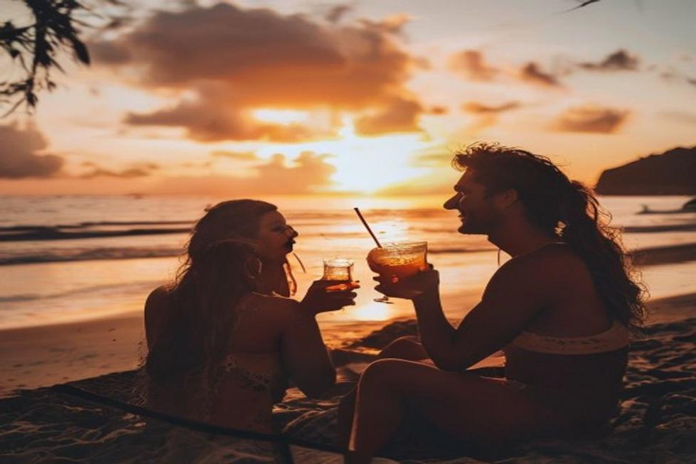Pôr do sol na praia de Recife com um casal aproveitando o momento.