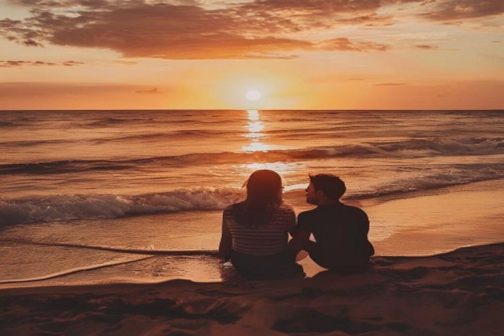 Casal desfrutando de um momento romântico na praia de Recife ao pôr do sol.